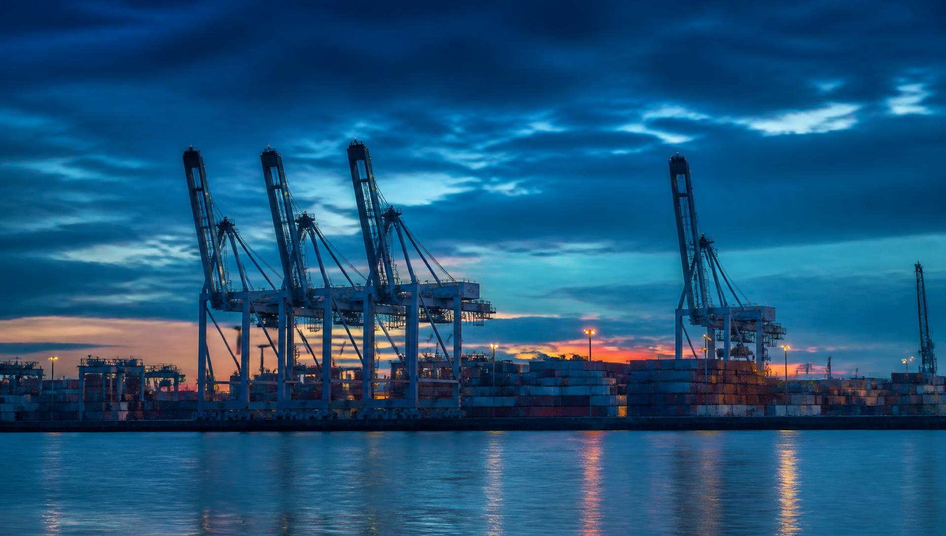 Container terminal at dawn with gantry cranes and stacked containers